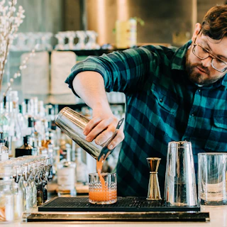 Bartender at Annette pours creative cocktail in Aurora Colorado
