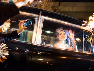 bride waving as car drives away